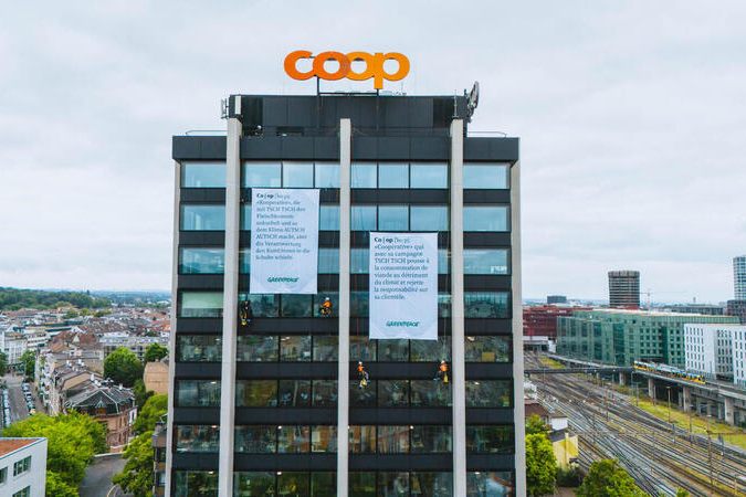 Greenpeace hängt Banner an Coop-Hauptsitz