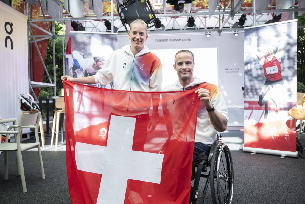 Marcel Hug und Elena Kratter tragen die Schweizer Fahne